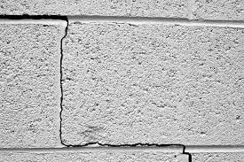 Riss in verputzter Betonwand, sichtbare Beschädigung vor Fassadenreinigung der Hausfassade.
